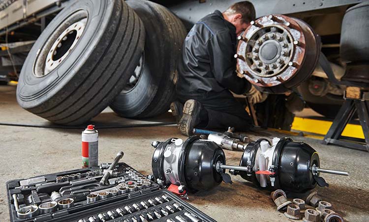 truck repair service. mechanic works with brakes in truck workshop